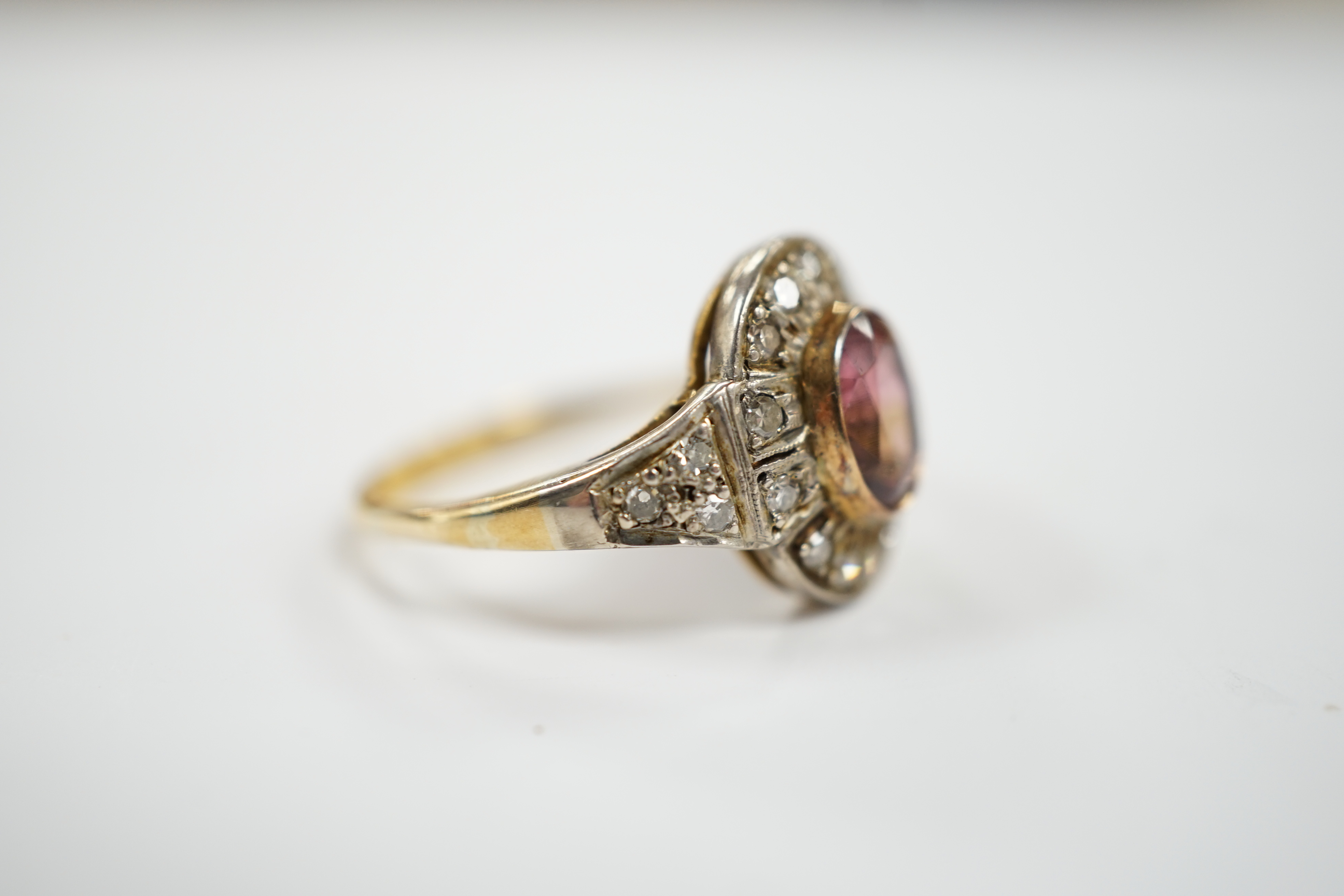 An 18ct, deep pink tourmaline and diamond set oval cluster ring, size P/Q, 4.4 grams